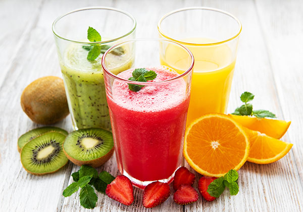 3 verres de jus de fruits : kiwi, fraise et orange