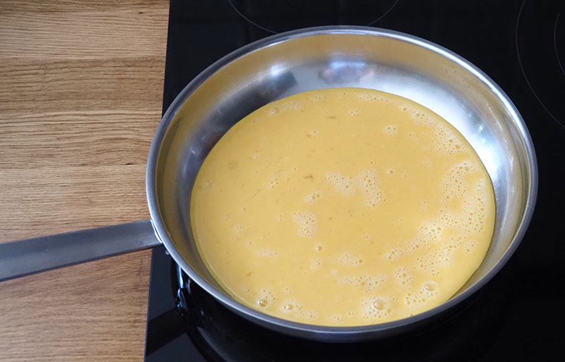 cuisson de l'omelette dans la poêle en inox